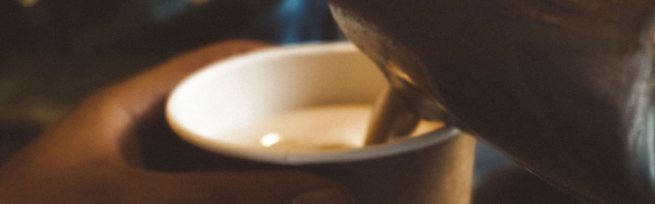 Latte-Art wird in einem To-Go-Becher angerichtet.